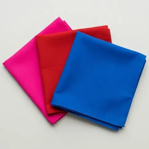 Three folded fabric squares in clean shocking pink, scarlet and electric blue