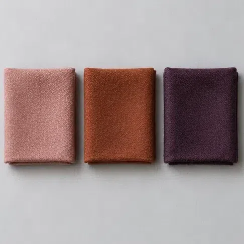 Three fabric squares in a row - dusty rose, warm terracotta and deep eggplant