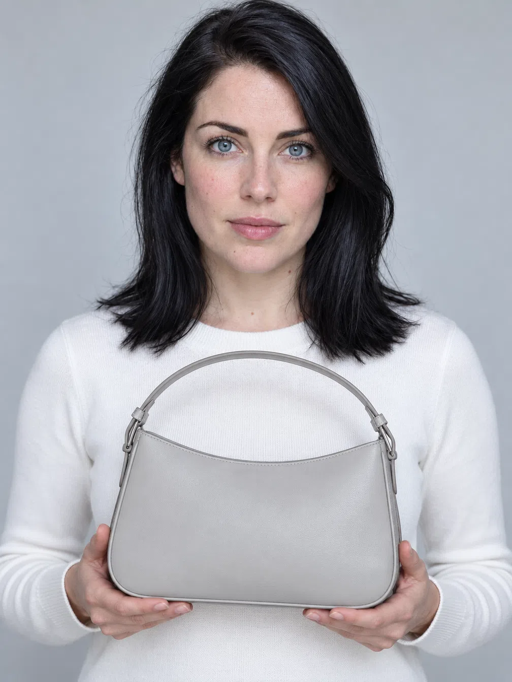 A structured bag held by a Bright Winter with blue eyes, recolored through saturated accents over a neutral knit