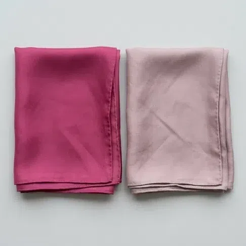 A clear raspberry-fuchsia scarf beside a grayed dusty rose one