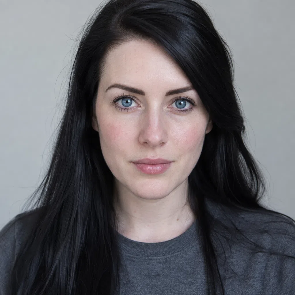 Fair Cool Winter portrait: pink-toned porcelain and long ink-dark hair against a gray backdrop