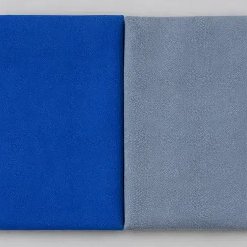 A clear sapphire fabric square beside a smoky gray-blue one