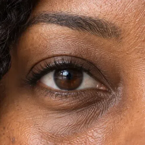 A dark brown Deep Autumn iris, bitter chocolate with a faint amber glow near the pupil