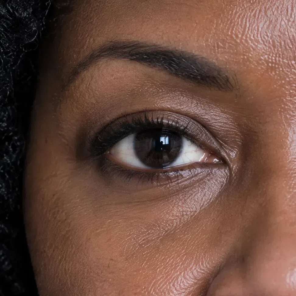 Macro of a velvety black-brown Deep Winter iris on a deep complexion