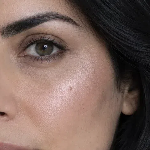 Pink pearl highlighter on a light olive Deep Winter complexion