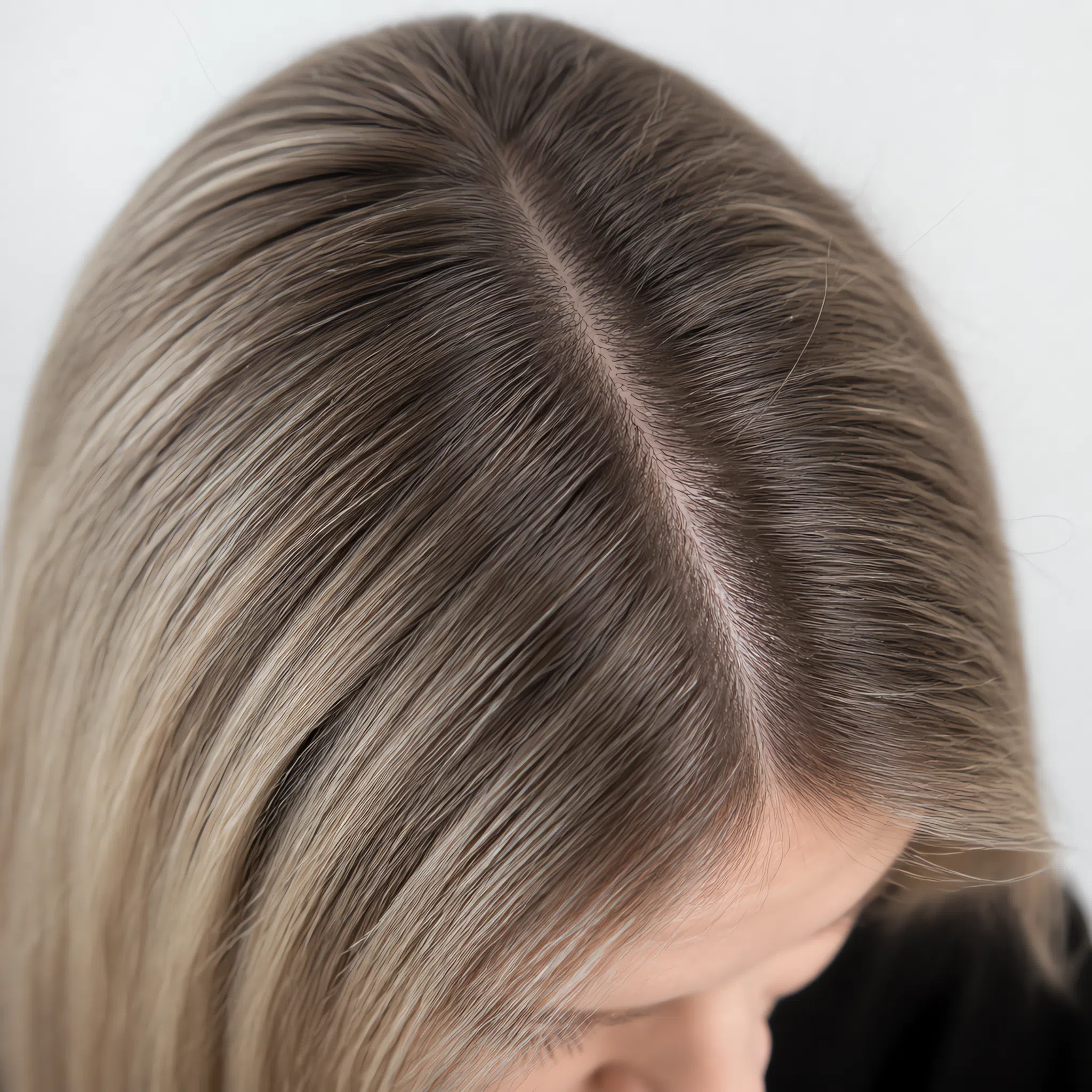 Mousy level 6 regrowth against level 8 ash blonde, a soft shadow along the parting