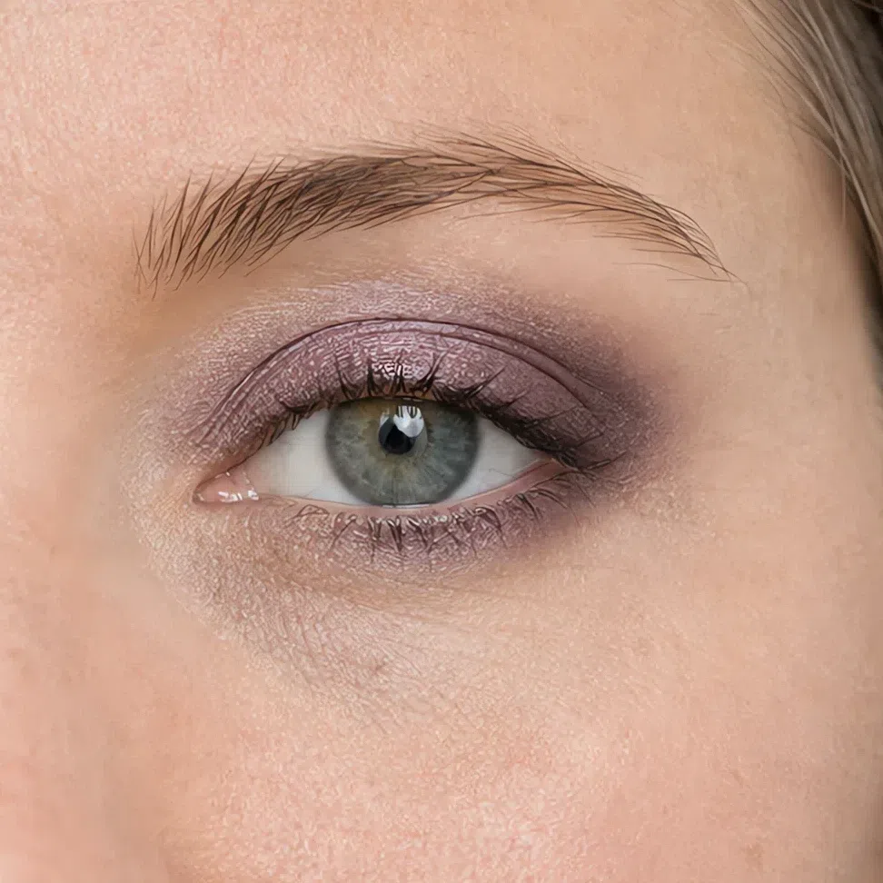 Cool plum shadow smudged soft across the lid