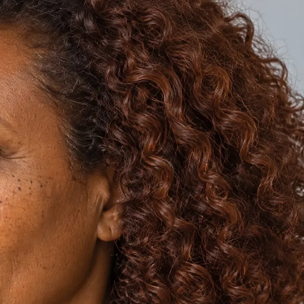 Dark bronze-brown curls with auburn glints on a deep-complexion Warm Autumn