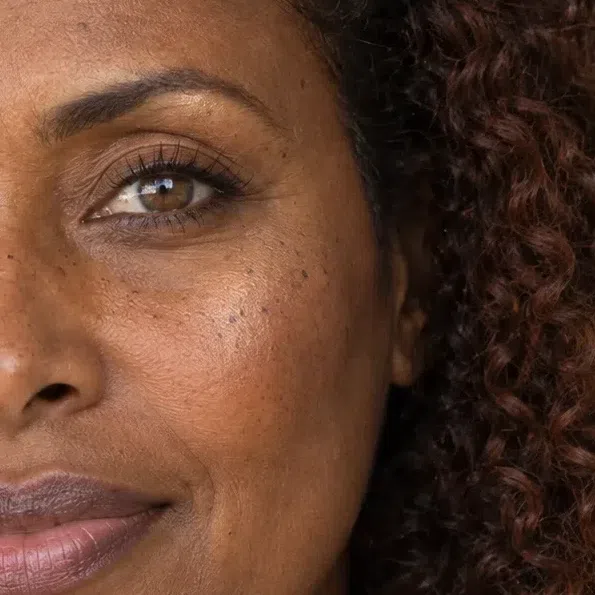 Bronze-glow highlighter on a deep brown cheekbone