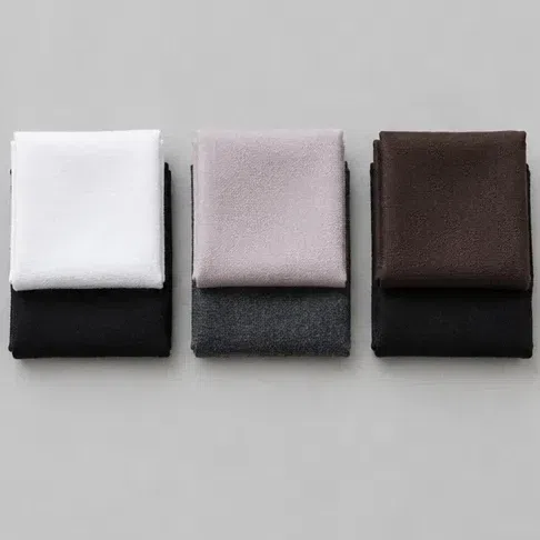 Three pairs of fabric squares - white on black, rose-beige on charcoal, and deep brown on black