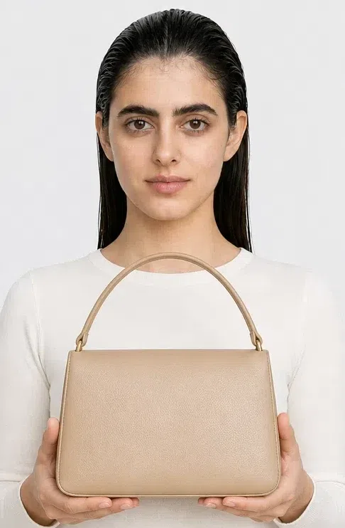 A structured top-handle bag held at the waist, repainted in Deep Autumn pairings